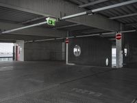 a picture of the inside of a large building, which is empty and has only one exit sign