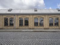 a brick building sits behind an empty parking lot outside a residential building in the city