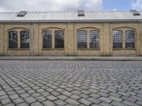 a brick building sits behind an empty parking lot outside a residential building in the city