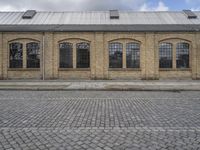 a brick building sits behind an empty parking lot outside a residential building in the city