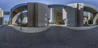 a very wide angle panoramic picture showing an urban intersection in front of a building