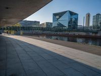 a skateboarder riding on a cement ramp next to a city street under a bridge