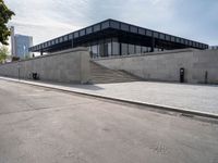 the building is next to a parking meter and two stairs outside of it and people standing at one end