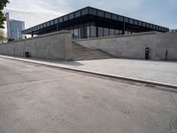 the building is next to a parking meter and two stairs outside of it and people standing at one end