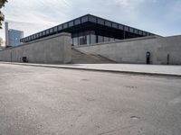 the building is next to a parking meter and two stairs outside of it and people standing at one end