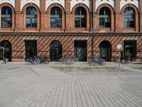 bicycles parked outside an old brick building in a street with brick walkways and windows