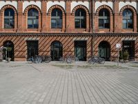 bicycles parked outside an old brick building in a street with brick walkways and windows