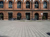 bicycles parked outside an old brick building in a street with brick walkways and windows