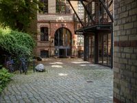 a courtyard with a patio and a fire place and a bench on the ground of the street