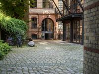 a courtyard with a patio and a fire place and a bench on the ground of the street