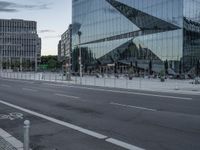 street scene with buildings and a parking meter in front of a glassy building on the side of the highway