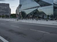 street scene with buildings and a parking meter in front of a glassy building on the side of the highway