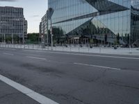 street scene with buildings and a parking meter in front of a glassy building on the side of the highway