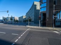 the sun is shining on a empty road in front of large buildings and traffic lights