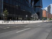 an empty road that has a street sign by it on the side of it and another white pole near the road