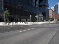 an empty road that has a street sign by it on the side of it and another white pole near the road