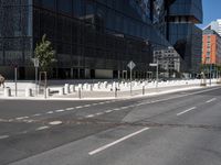 an empty road that has a street sign by it on the side of it and another white pole near the road