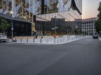 an intersection with a view of a modern building at sunset or dawn in a european city