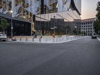 an intersection with a view of a modern building at sunset or dawn in a european city