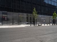 a person riding a bicycle near an elevator door near some trees and metal poles in front of a building