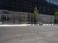 a person riding a bicycle near an elevator door near some trees and metal poles in front of a building