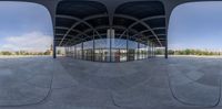 an outdoor space with circular mirrors on the side of it and trees on both sides of the wall