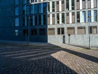 an empty stone street with tall buildings and buildings in the background in the city of leipzig