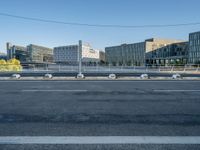 the street is empty and there are some benches along with buildings in the background for example,