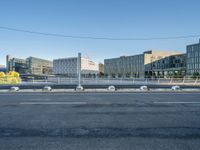 the street is empty and there are some benches along with buildings in the background for example,