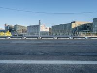 the street is empty and there are some benches along with buildings in the background for example,