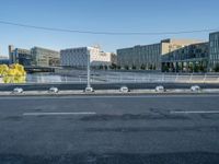 the street is empty and there are some benches along with buildings in the background for example,