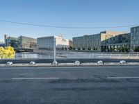 the street is empty and there are some benches along with buildings in the background for example,