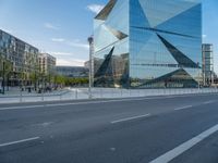 there is a man riding a bike near the side of a building with a glass tower