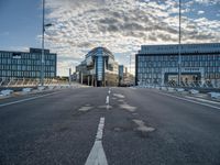 the empty street on top of a street that leads to some office buildings near an airport