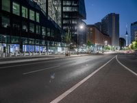 a street view with a building in the background at dusk with no cars on the street