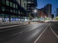 a street view with a building in the background at dusk with no cars on the street