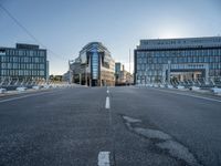 empty streets are shown on either side of the buildings, with blue skies and sunshine shining