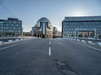 empty streets are shown on either side of the buildings, with blue skies and sunshine shining