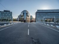 empty streets are shown on either side of the buildings, with blue skies and sunshine shining