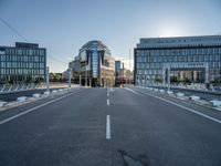 empty streets are shown on either side of the buildings, with blue skies and sunshine shining