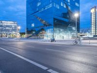 people on the street in front of building on the road at night time during twilight