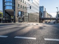 a big building with a tall, glassy structure in it and there is an exit sign on the sidewalk