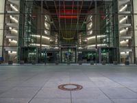 a very big square with some stairs and windows at night time with a fire hydrant sitting in front of it