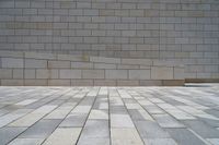 the wall is made out of many different sized stones of grey colors and tiles of light colors