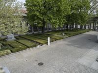 a courtyard in the middle of town that contains a number of formal gardens and benches