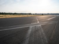 the runway is empty of cars or motorcycles on it while the sun shines brightly