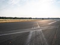 the runway is empty of cars or motorcycles on it while the sun shines brightly