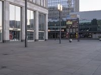 people walking around a large city square on a bright day in the daytime sun,