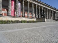 two people riding bicycles in front of the museum of fine arts and crafts, paris