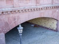a brick bridge with two old lamps and an ornately decorated design on the side of the bridge